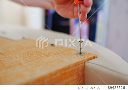 hands with screwdriver assembles furniture. carpenter and handyman services hands with screwdriver assembles furniture. carpenter and handyman services 89428526