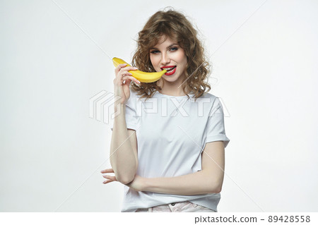 portrait of a beautiful girl holding a banana in her hands portrait of a beautiful girl holding a banana in her hands 89428558