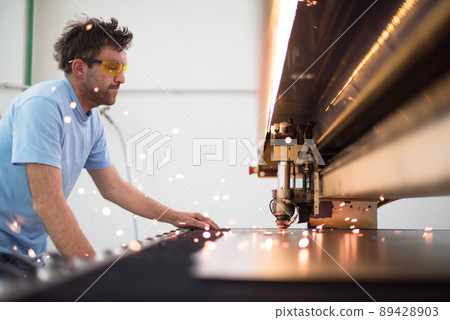 Within heavy industry. A man works in a modern factory on a CNC machine. Selective focus 89428903