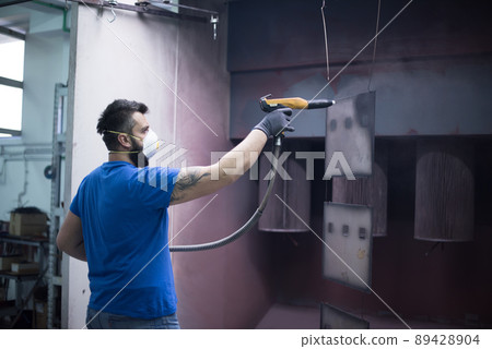 The painter paints the iron element. Industrial painting parts. Metal designs  89428904