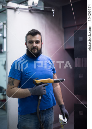 The painter paints the iron element. Industrial painting parts. Metal designs  89429474