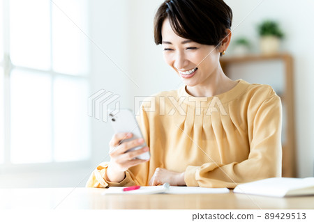 用智能手機學習的中年婦女 用智能手機學習的中年婦女 89429513