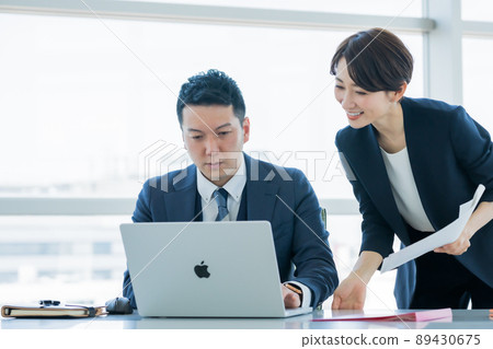 從女性員工那裡接受工作內容說明的經理 從女性員工那裡接受工作內容說明的經理 89430675