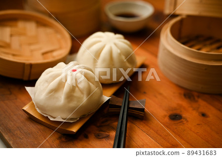 Chinese cuisine, Fresh steamed pork buns on a wood plate 89431683