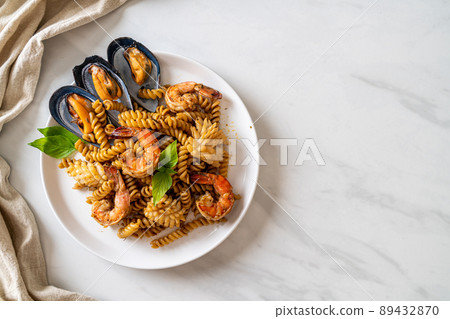stir-fried spiral pasta with seafood and basil sauce stir-fried spiral pasta with seafood and basil sauce 89432870