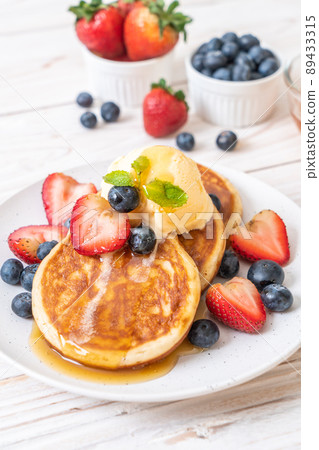 pancake with blueberries, strawberries, honey and vanilla ice-cream pancake with blueberries, strawberries, honey and vanilla ice-cream 89433315