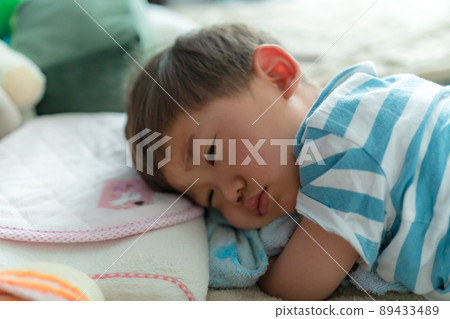 A child taking a nap, waking up, in a bad mood 89433489
