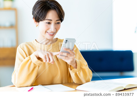 在家學習時使用智能手機的中年婦女 89433977