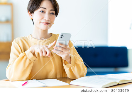 在家學習時使用智能手機的中年婦女 89433979