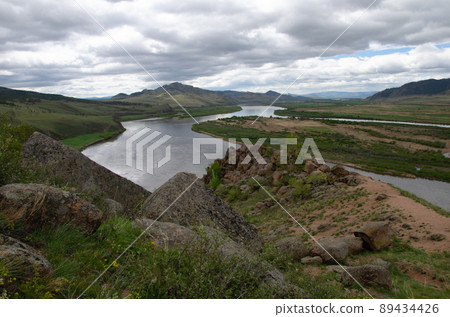 The valley of the river under an overcast cloudy sky. View of the river from a height. The valley of the river under an overcast cloudy sky. View of the river from a height. 89434426