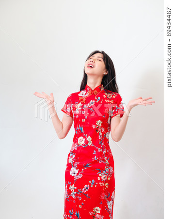 Portrait of young asian woman wearing traditional cheongsam qipao dress over isolated white background holding copyspace with two hands. Portrait of young asian woman wearing traditional cheongsam qipao dress over isolated white background holding copyspace with two hands. 89434487