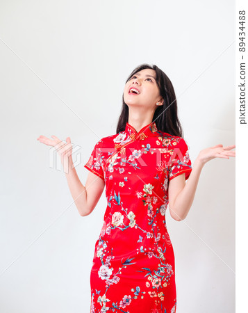 Portrait of young asian woman wearing traditional cheongsam qipao dress over isolated white background holding copyspace with two hands. Portrait of young asian woman wearing traditional cheongsam qipao dress over isolated white background holding copyspace with two hands. 89434488