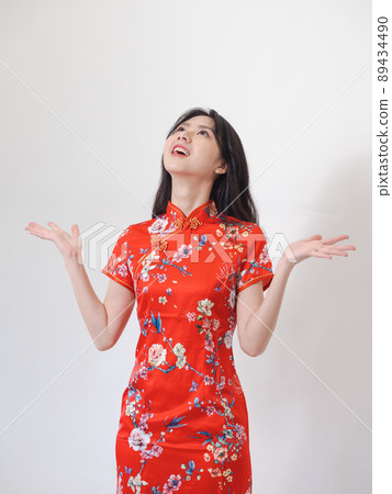 Portrait of young asian woman wearing traditional cheongsam qipao dress over isolated white background holding copyspace with two hands. Portrait of young asian woman wearing traditional cheongsam qipao dress over isolated white background holding copyspace with two hands. 89434490