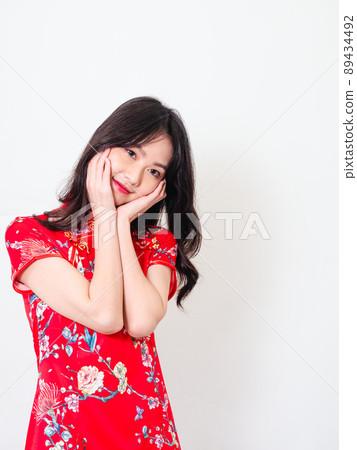 Portrait of young asian woman wearing traditional cheongsam qipao dress touch face on white background. Portrait of young asian woman wearing traditional cheongsam qipao dress touch face on white background. 89434492