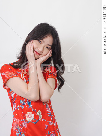 Portrait of young asian woman wearing traditional cheongsam qipao dress touch face on white background. Portrait of young asian woman wearing traditional cheongsam qipao dress touch face on white background. 89434493