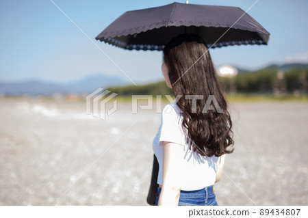 Woman walking on the beach 89434807