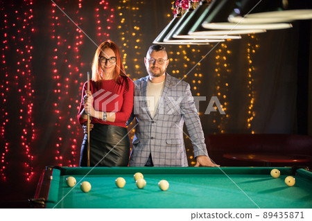 Billiard club. A nice pretty married couple standing by the table 89435871