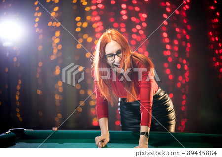 Laughing ginger woman playing billiard in nice architected club Laughing ginger woman playing billiard in nice architected club 89435884