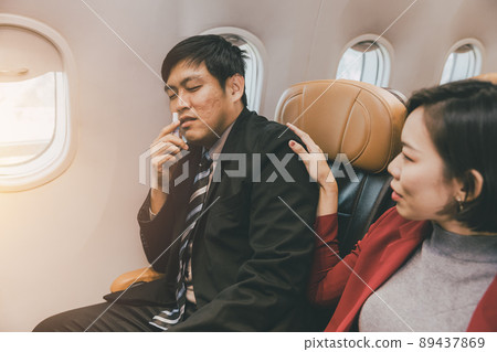 Asian businessman male motion sick health problem during fly on board in flight cabin. Asian businessman male motion sick health problem during fly on board in flight cabin. 89437869