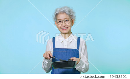 穿著圍裙做飯的高級女人 89438201