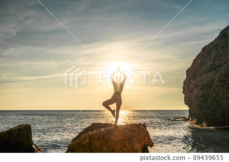 Girl gymnast is training on the beach by the sea sunset. Does twine. Photo series. Girl gymnast is training on the beach by the sea sunset. Does twine. Photo series. 89439655