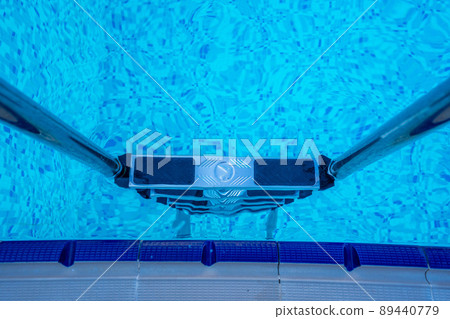 Background of blue transparent water in the swimming pool on the territory of the hotel. Descent to the pool with handrails. Rest and relaxation concept. Active rest by the sea 89440779