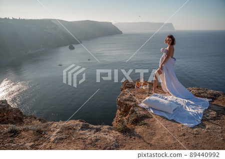 Woman wake up in bed wuth duvet and pillow over nature sea background outdoors. Back view. Good morning. Freedom concept. Woman wake up in bed wuth duvet and pillow over nature sea background outdoors. Back view. Good morning. Freedom concept. 89440992