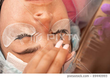 Eyelash extension procedure. Woman eye with long eyelashes. lashes, close up, macro, selective focus. Eyelash extension procedure. Woman eye with long eyelashes. lashes, close up, macro, selective focus. 89440993