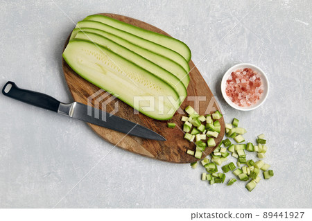 Zucchini sliced and cubes on a wooden cutting board and pink salt Zucchini sliced and cubes on a wooden cutting board and pink salt 89441927