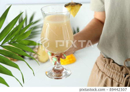 Woman holds pina colada cocktail, close up Woman holds pina colada cocktail, close up 89442307