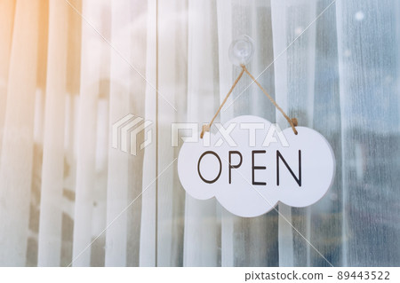 A business sign that says Open on cafe or restaurant hang on door at entrance. A business sign that says Open on cafe or restaurant hang on door at entrance. 89443522