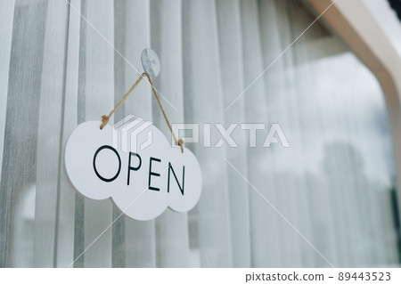 A business sign that says Open on cafe or restaurant hang on door at entrance. 89443523