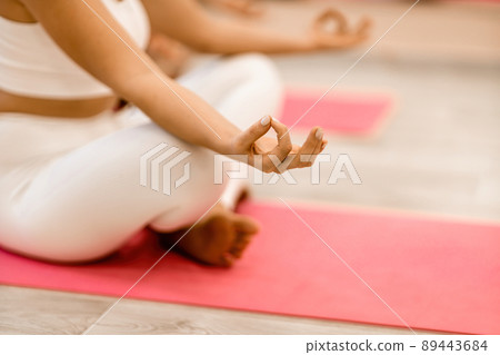 Girl does yoga. Young woman practices asanas on a beige one-ton background. 89443684