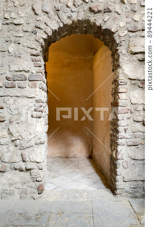 Aged narrow dark vaulted passage 89444221