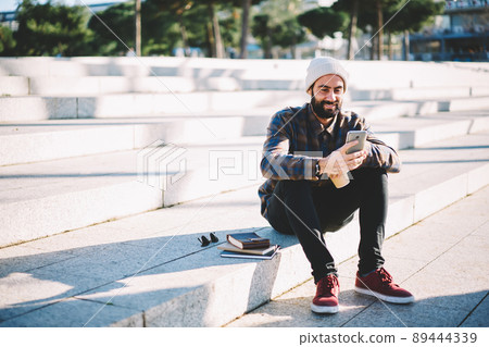 Middle Eastern student chatting with followers from social network via app on mobile phone Middle Eastern student chatting with followers from social network via app on mobile phone 89444339