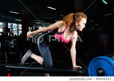 attractive young woman engaged with dumbbells in the gym. attractive young woman engaged with dumbbells in the gym. 89444341