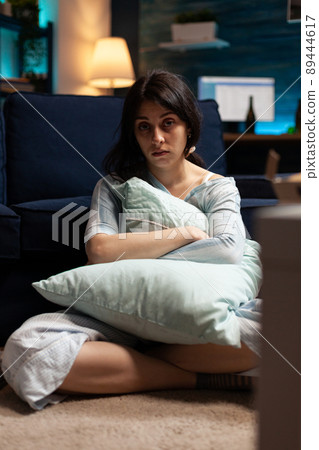 Portrait of sad woman with depression sitting on floor, having suicidal thoughts. Depressed poor person dealing with chronic mental disease difficulties and feeling anxious in solitude. 89444617
