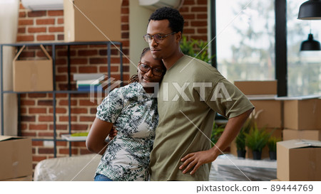 Husband and wife hugging each other and celebrating life event, buying apartment on mortgage loan to move in together. Sharing embrace, enjoying family home relocation. Handheld shot. 89444769