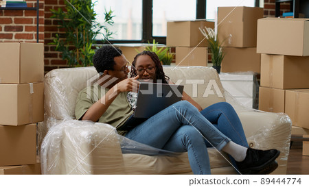 Man and woman buying furniture online on website to decorate new household property. Looking at interior decor inspiration on laptop to prepare apartment for new beginnings. Handheld shot. Man and woman buying furniture online on website to decorate new household property. Looking at interior decor inspiration on laptop to prepare apartment for new beginnings. Handheld shot. 89444774