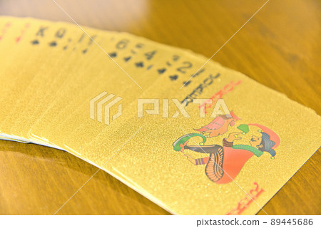 桌上一字排開的金色撲克牌 桌上一字排開的金色撲克牌 89445686