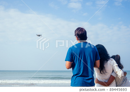 happy indian family are operating the drone by remote control in the beach in Goa happy indian family are operating the drone by remote control in the beach in Goa 89445693