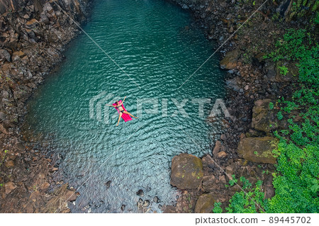 girl floating in the lake water relaxing on pink inflatable mattress in blue swimmingpool remote work and freelance top view green tree luxury eco hotel in Goa India girl floating in the lake water relaxing on pink inflatable mattress in blue swimmingpool remote work and freelance top view green tree luxury eco hotel in Goa India 89445702