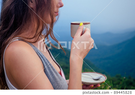 girl drinking cup of hot tea on top mountain in india herb plantation girl drinking cup of hot tea on top mountain in india herb plantation 89445828