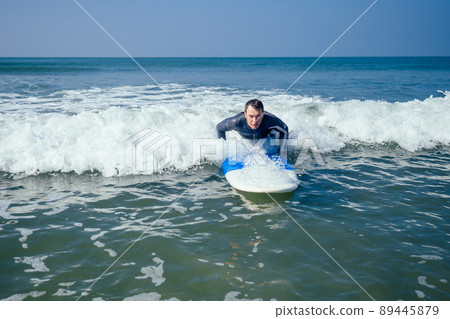 surf instructor showing how riding on big waves in Goa India 89445879