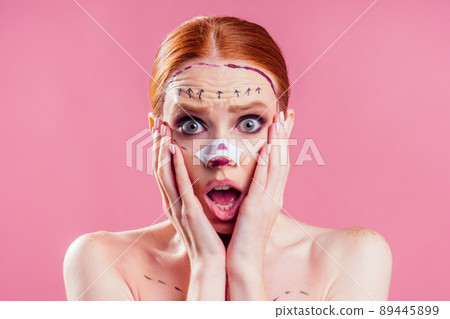 caucasian panic female cosmetic lifting procedure in studio pink background 89445899