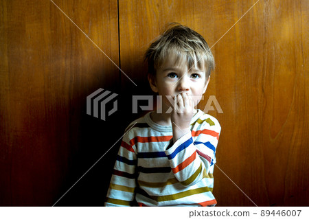 Little boy eating a piece of bread. Portrait of little sad refugee in ruined building. Refugees, war crisis, humanitarian disaster concept. Little boy eating a piece of bread. Portrait of little sad refugee in ruined building. Refugees, war crisis, humanitarian disaster concept. 89446007