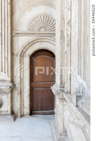 Wooden ornate door over white marble decorated wall 89446820