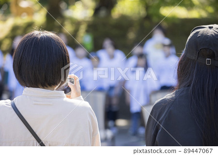 一位女士的母親在她的智能手機上拍攝一場戶外音樂會 89447067