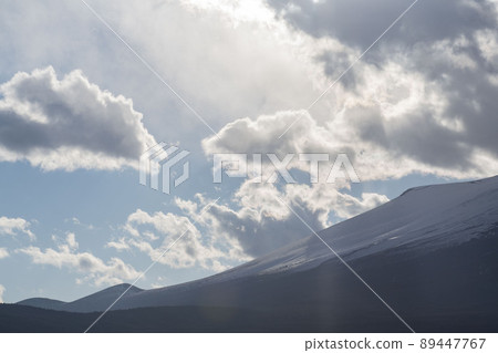 Light shining through the gap between Mt. Fuji covered with snow and clouds 89447767