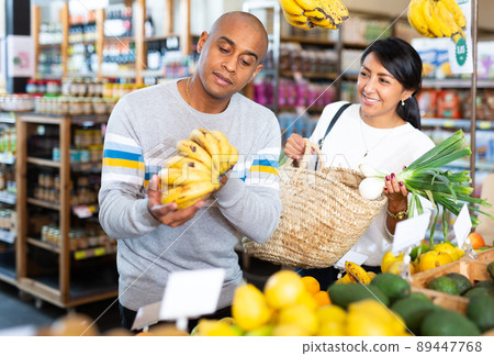 Married couple picking ripe bananas together at supermarket 89447768